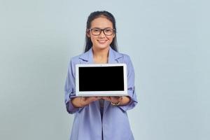 portrait d'une jeune femme d'affaires asiatique joyeuse montrant un écran d'ordinateur portable vierge pour présenter des produits isolés sur fond blanc