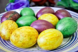 beaucoup de beaux oeufs de pâques colorés sur une assiette photo