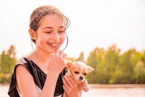 adolescente et chien chihuahua dans ses bras. belle fille près de la rivière. photo