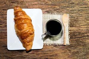 café expresso et croissant en plaque blanche sur table en bois photo