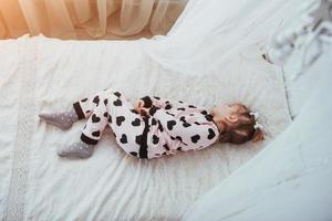 enfant en pyjama doux et chaud jouant au lit photo