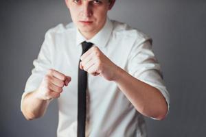 homme d'affaires en tenue d'affaires boxe sur fond sombre dans le studio photo