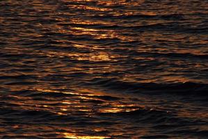 le soleil reflète les vagues au lever du soleil photo