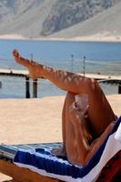 femme en bikini se trouve détendu sur la plage photo