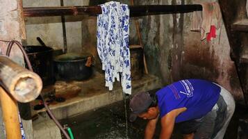 activité de fabrication de batik, création et conception de tissu blanc à l'aide de canting et de cire en claquant sur le tissu, pekalongan, indonésie, 7 mars 2020 photo