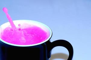 tasse noire avec un liquide rose photo