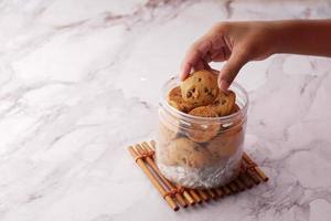 cueillir à la main des biscuits sucrés dans un pot en plastique photo