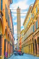 bologne, italie, 17 mars 2019 rue italienne typique, bâtiments avec colonnes et tour médiévale garisenda dans le vieux centre-ville historique, émilie-romagne photo