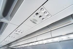 panneau de commande de climatisation d'avion au-dessus des sièges, air étouffant dans la cabine de l'avion avec des personnes, nouvelle compagnie aérienne à bas prix. photo