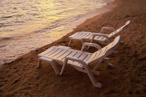 coucher de soleil sur la mer pataya beach thaïlande avec chaise de plage photo