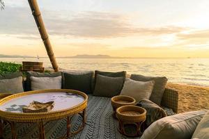 oreillers sur la chaise longue du patio extérieur sur la plage avec l'heure du coucher du soleil photo