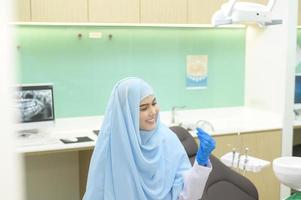 jeune femme dentiste musulmane tenant invisalign dans une clinique dentaire, contrôle des dents et concept de dents saines photo