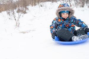 toboggan à cheval sur l'activité hivernale des enfants photo