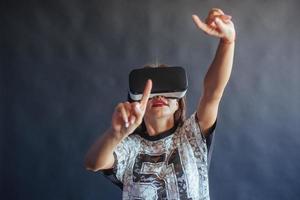 une femme heureuse acquiert de l'expérience dans l'utilisation d'un casque de réalité virtuelle vr-glasses. photo