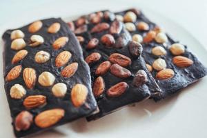 chocolat noir, isolé sur blanc avec des noix entières. photo