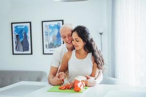 beau jeune couple broie des légumes ensemble dans la cuisine. photo