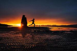 est un rocher spectaculaire dans la mer sur la côte nord de l'islande. sur cette photo hvitserkur se reflète dans l'eau de mer après le coucher du soleil de minuit