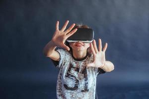 une femme heureuse acquiert de l'expérience dans l'utilisation d'un casque de réalité virtuelle vr-glasses. photo