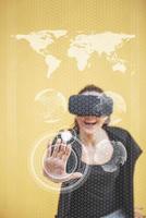 une femme heureuse dans le studio acquiert l'expérience de l'utilisation d'un casque de réalité virtuelle vr-glasses. technologies innovantes. la notion de sécurité. tenant une planète terre rougeoyante photo