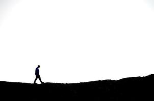 homme en randonnée sur une montagne avec un ciel blanc photo