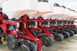 gros plan du semoir attaché au tracteur dans le champ. machines agricoles pour travaux de printemps semis photo