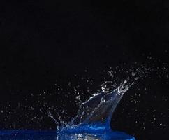 éclaboussure de couronne d'eau sur la surface bleue. photo