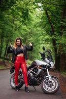 une jolie fille sexy sur une moto de sport posant à l'extérieur photo