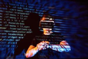 la double exposition d'un homme caucasien et d'un casque de réalité virtuelle est vraisemblablement un joueur ou un pirate qui craque le code dans un réseau ou un serveur sécurisé, avec des lignes de code photo