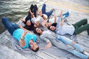 un groupe d'amis jeunes et prospères en vacances profitant d'un jeu sur le lac. Émotions positives. photo