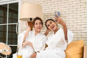 deux amies asiatiques discutent en attendant dans la zone de réception du spa photo