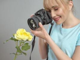 photographe de jeune femme tirant une rose jaune avec un appareil photo numérique. gros plan, tir, passe-temps, concept de profession