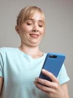 mauvaise pose de faire selfie. belle blogueuse blonde élégante faisant selfie avec son smartphone près de la fenêtre. tendance, technologie, beauté, concept de mode photo