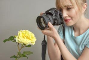 photographe de jeune femme tirant une rose jaune avec un appareil photo numérique. gros plan, tir, passe-temps, concept de profession