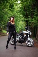 une jolie fille sexy sur une moto de sport posant à l'extérieur photo