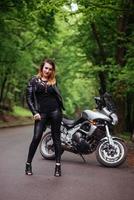 une jolie fille sexy sur une moto de sport posant à l'extérieur photo