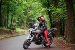 une jolie fille sexy sur une moto de sport posant à l'extérieur photo