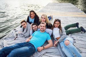 groupe de beaux jeunes sur la jetée, la satisfaction des amis crée une vie émotionnelle photo