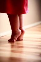 pieds de bébé qui s'étendent sur un plancher en bois photo