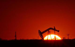 Pompe à huile dans le champ de la Saskatchewan au coucher du soleil photo