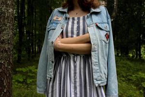 jeune femme en veste en jean et robe rayée photo