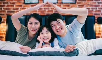 jeune famille asiatique sur le lit photo