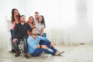 portrait de groupe de garçons et de filles multiethniques avec des vêtements à la mode colorés tenant un ami et posant sur un mur de briques, des gens de style urbain s'amusant, des concepts sur la jeunesse et le mode de vie photo