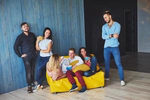 portrait de groupe de garçons et de filles multiethniques avec des vêtements à la mode colorés tenant un ami et posant sur un mur de briques, des gens de style urbain s'amusant, des concepts sur la jeunesse et le mode de vie photo