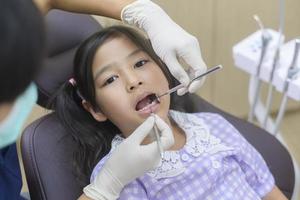 une petite fille mignonne ayant des dents examinées par un dentiste dans une clinique dentaire, un contrôle des dents et un concept de dents saines
