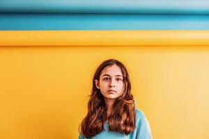 fille pour la paix, arrêtez la guerre. fille dans un sweat à capuche bleu sur fond jaune et bleu. photo