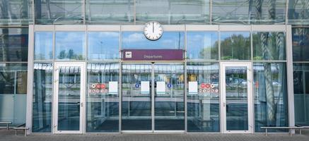 portes vitrées fermées de l'aéroport avec un panneau de départ photo