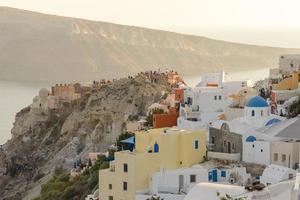 les touristes rencontrent le coucher du soleil dans le village d'oia, santorin. photo