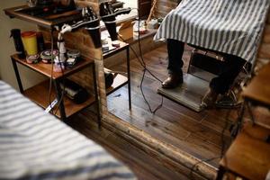 gros plan sur les jambes de l'homme dans un fauteuil de coiffeur photo