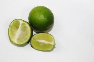 les limes sont vertes et certaines ont été fendues sur un fond gris photo