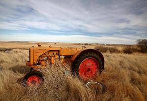 tumbleweeds empilés contre un tracteur abandonné photo